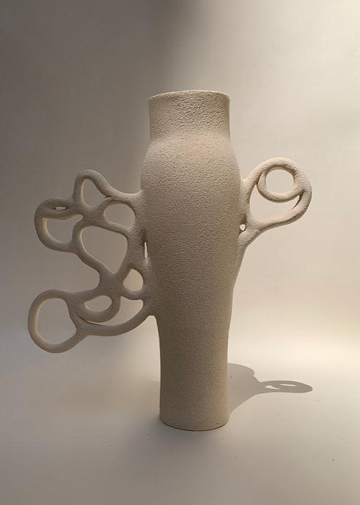 Vase en grès blanc avec une surface texturée, présentant une forme élégante et moderne. Le vase est décoré de motifs organiques en relief, ressemblant à des branches entrelacées, ajoutant une touche artistique à son design. Il est positionné sur un fond neutre, mettant en valeur sa couleur blanche et sa structure unique.